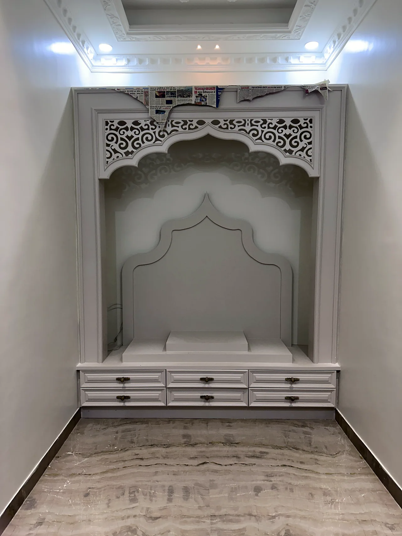 Dedicated mandir alcove with carved detailing and storage