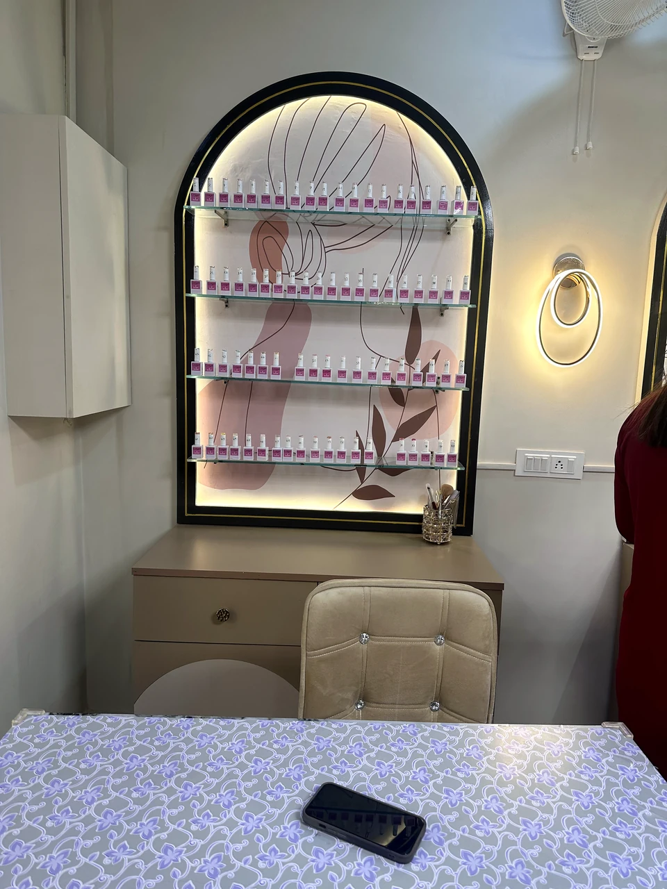 Close view of the salon’s arched nail polish display and integrated lighting