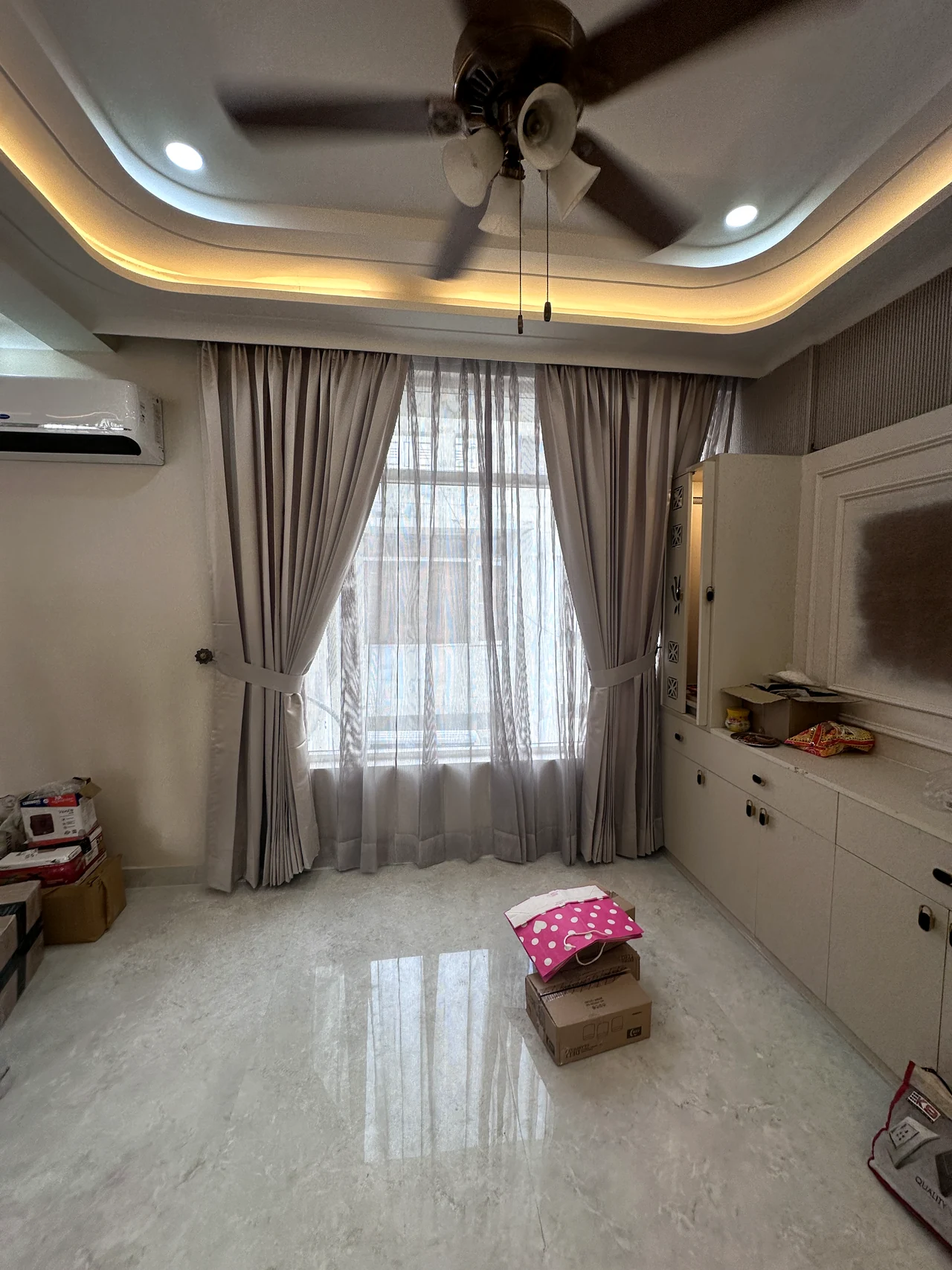Bedroom with soft neutral finishes, wardrobe storage and a layered ceiling