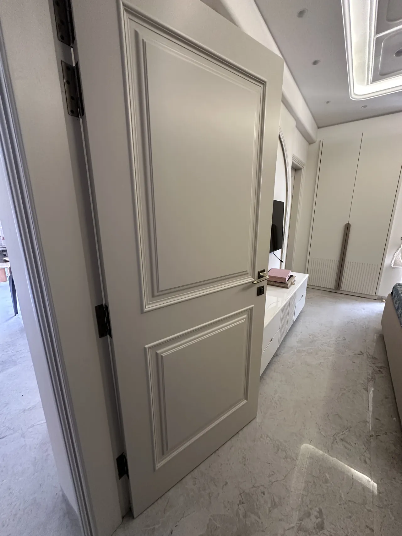 Moulded interior door with a view towards the TV wall and wardrobe